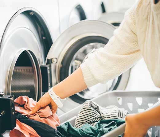 woman get5ting clothes out of a washer